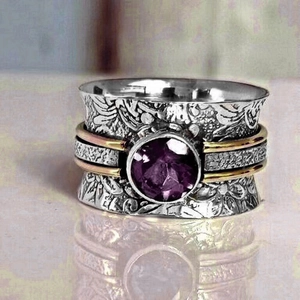 Macro shot of vintage silver ring with engraved floral patterns and purple gemstone