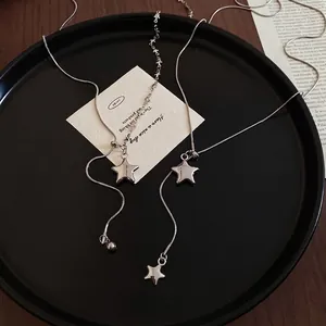 Minimalist silver star pendant necklace with smooth snake chain on elegant black plate
