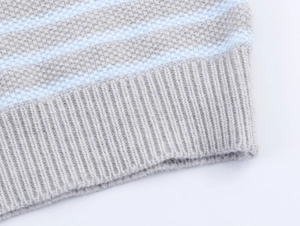 Dettaglio dell'orlo in maglia a coste con strisce blu chiaro su un gilet grigio