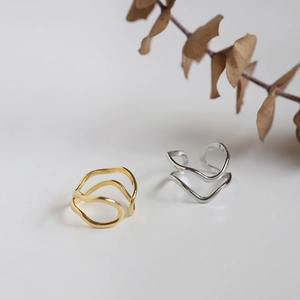 Detail of minimalist gold and silver double-layer wavy adjustable stainless steel rings