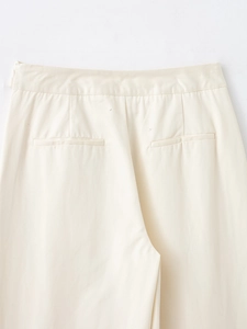 Détail de la taille haute du pantalon beige avec poches arrière et texture du tissu sergé