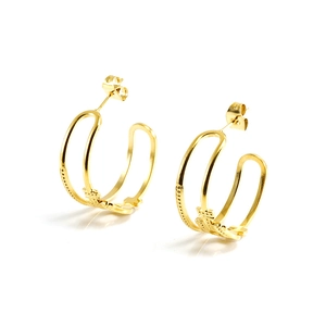 Détails de boucles d'oreilles créoles dorées avec textures multicouches et motifs