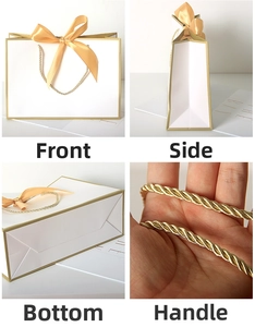 Detail view of white gift bag with gold edges, champagne ribbon bow and rope handles