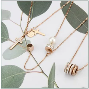 Close-up of 18k rose gold plated necklaces with various pendants and pearl details