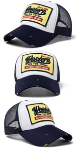 Three-way view of navy and white mesh trucker hat with yellow embroidered Western patch