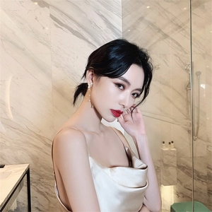Elegant long pearl tassel drop earrings worn by a model in a luxury setting