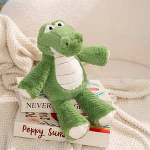 Cute green long-legged crocodile plush toy sitting on decorative books in a home setting