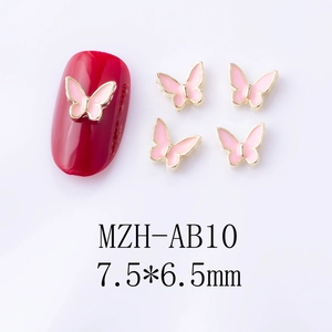 Macro detail of 7.5x6.5mm pink enamel butterfly nail charms with gold alloy edges