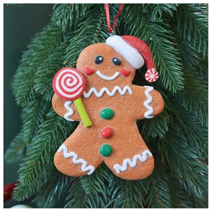 Close-up of a gingerbread man ornament with sugar texture hanging on a Christmas tree