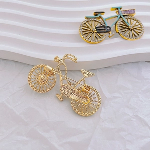 Detailed view of bicycle brooch with blue frame, rhinestone wheels and secure safety pin