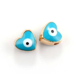 Close-up of heart-shaped evil eye jewelry connectors in sky blue and gold plating