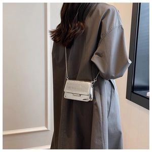 Silver crocodile embossed mini crossbody bag with metal chain shown on model's back
