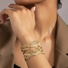 Close-up of golden woven multi-strand wide cuff bracelet on a model wrist