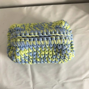 Detail of blue and lime green woven crochet bag showing thick knit texture and dual colors