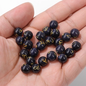 10mm blue goldstone zodiac beads with gold symbols held in hand for DIY jewelry making