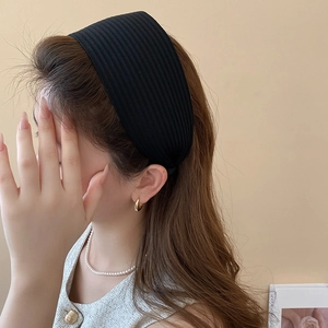 Detail der gerippten Strickstruktur und des breiten Designs des schwarzen Stirnbands