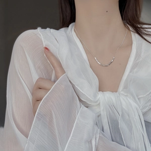 Minimalist 925 sterling silver geometric cube necklace on a model in white blouse