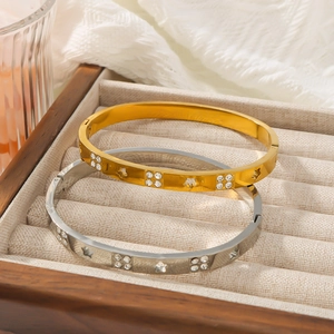 Gold and silver stainless steel star bangles with crystals in a wooden box