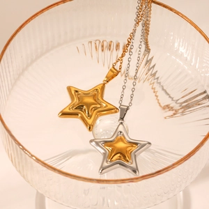 Detailed macro of 3D star pendants in gold and silver mix on a polished chain
