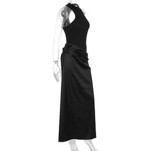 Détail de la jupe en satin noir montrant les plis fluides à la taille et le drapé