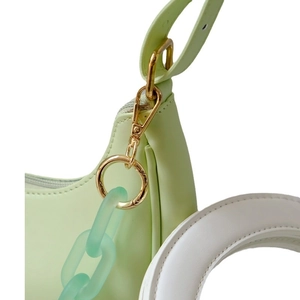 Mint green bag with golden metal buckle and frosted chain accessory on white background