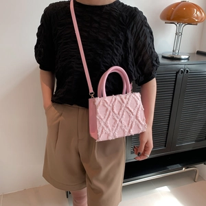 Pink canvas crossbody handbag with fringe diamond texture and adjustable leather strap