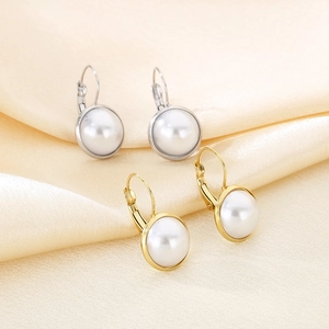 Elegant gold and silver round pearl hoop earrings displayed on premium beige silk fabric