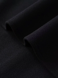 Close-up of black wool blend fabric showing thick texture and soft fuzzy surface