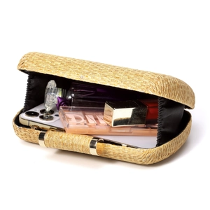 Detailed interior view of a woven evening clutch bag showing space for makeup and phone