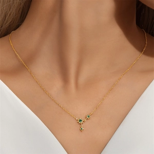 Close-up of golden S925 sterling silver star pendant necklace with green crystals on neck