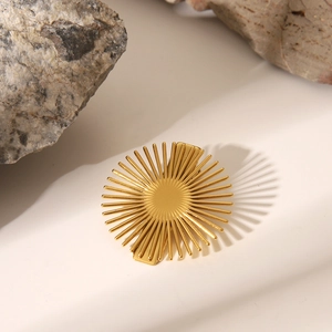 Détail macro de la barrette dorée en forme de soleil sur fond de pierre naturelle chic