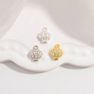 Detailed close-up of shell pendants with cubic zirconia inlay on white ceramic plate
