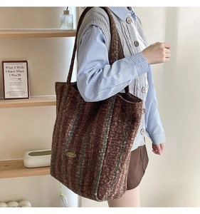 Brown striped plush tote bag showing detailed handmade metal label and soft wool texture