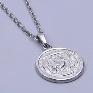 Macro shot of vintage silver owl coin pendant with ΑΘΕ engraving and fine chain