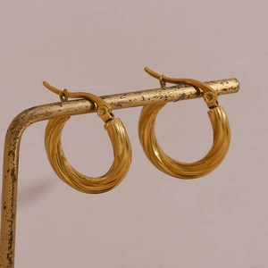Detailed side view showing golden twisted hoop earrings with 18K gold plated texture