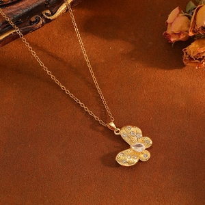 Detaillierte Ansicht einer goldenen Schmetterlingskette mit funkelnden Kristallen vor Vintage-Hintergrund