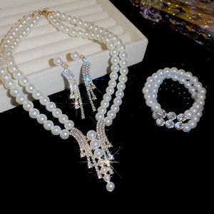Detailed close-up of a double-layer pearl necklace and earring set with crystals