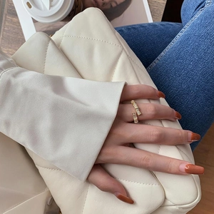 Gold bamboo-style open ring with micro-set zircons shown in a stylish lifestyle setting
