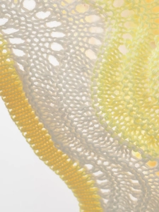 Macro view of wave-pattern yellow and white hollow-out knit fabric detail