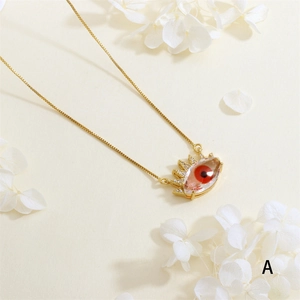 Detailed macro view of gold plated evil eye pendant with red stone and zircon stones