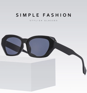Side view of chic black cat-eye sunglasses on a white pedestal with modern minimalist style
