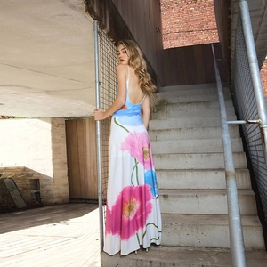 Close-up of vibrant pink and blue floral prints on a white backless maxi dress fabric