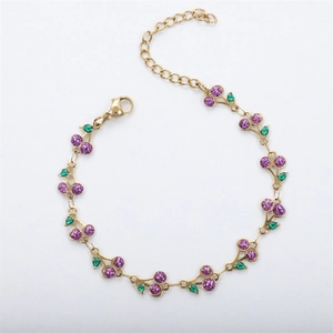 Detail of 18k gold chain bracelet with sparkling purple cherry pendant and green leaf