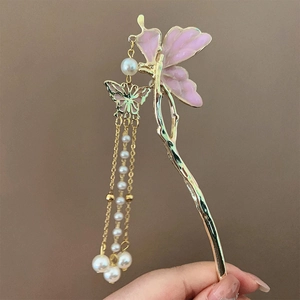 Detailed close-up of butterfly hair pin with pink enamel and elegant pearl tassels