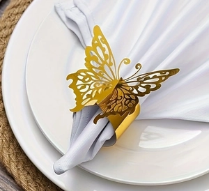 Detailed macro view of a golden metal butterfly napkin ring on a white napkin and ceramic plate