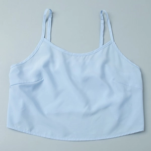 Detail of light blue crop top camisole featuring thin straps and bust darting design