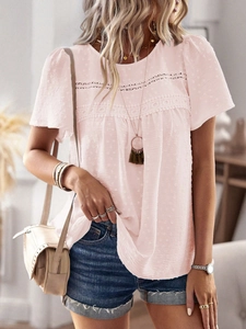 Detail of pink short-sleeve top showing delicate lace patchwork and polka dot texture
