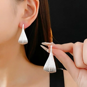 Minimalist leaf shaped earrings in silver with elegant vertical textured patterns
