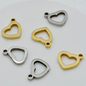 Close-up of heart-shaped hollow metal pendants in gold and silver finishes for DIY jewelry