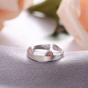 Detail of adjustable S925 silver cat ear ring with pink enamel on purple satin
